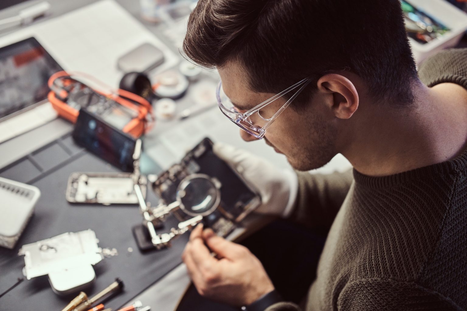 The technician repairing a damaged smartphone in the electronic workshop.
